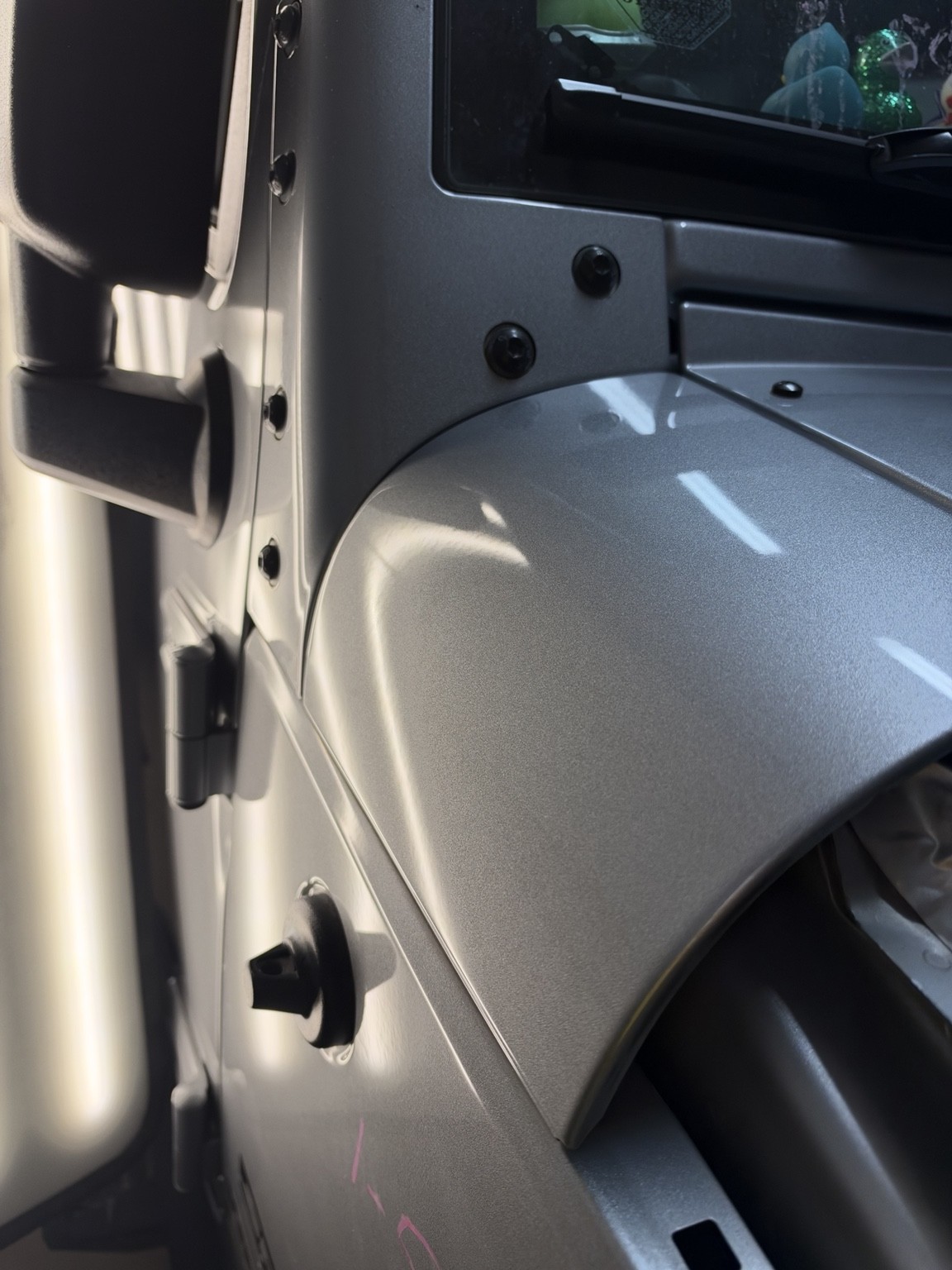 Silver vehicle panel after dent repair, viewed under a reflection lamp