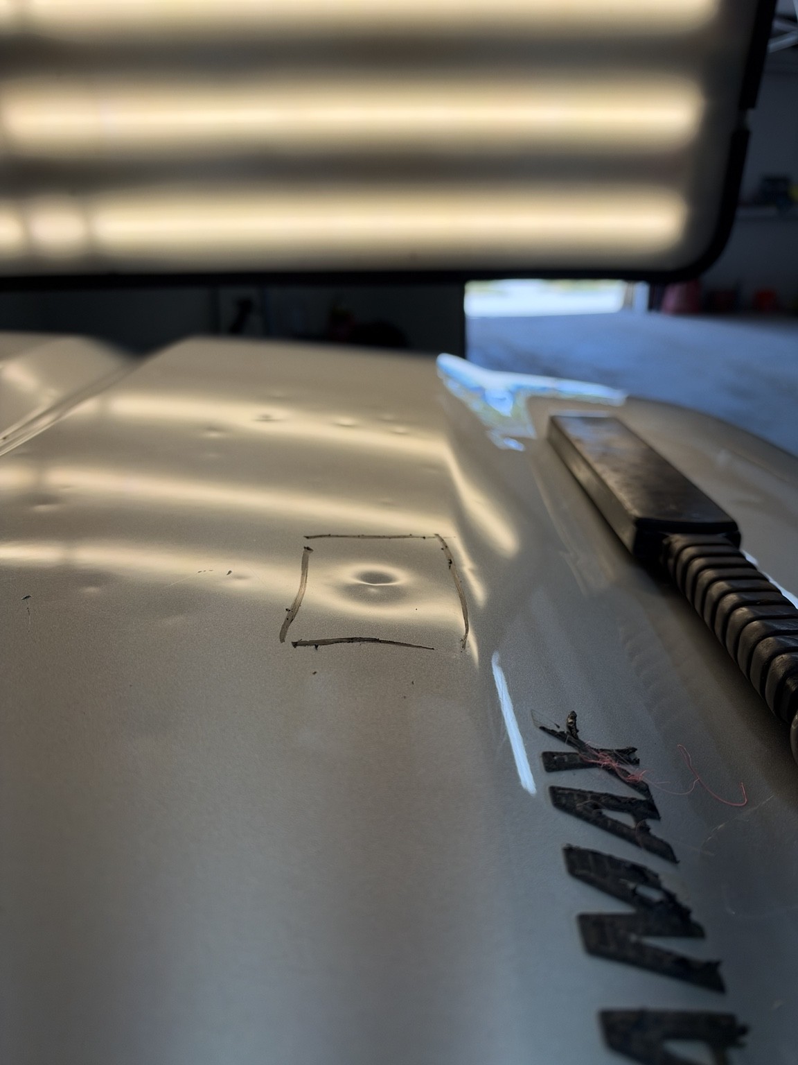 Before: dent inside a marked square under a PDR lamp
